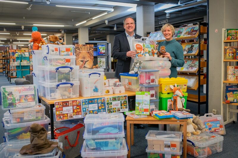 Bürgermeister Dirk Breuer und Barbara Hoevels, Leiterin der Hürther Stadtbücherei, mit einigen Gegenständen, die nun in der „Bibliothek der Dinge“ ausgeliehen werden können.